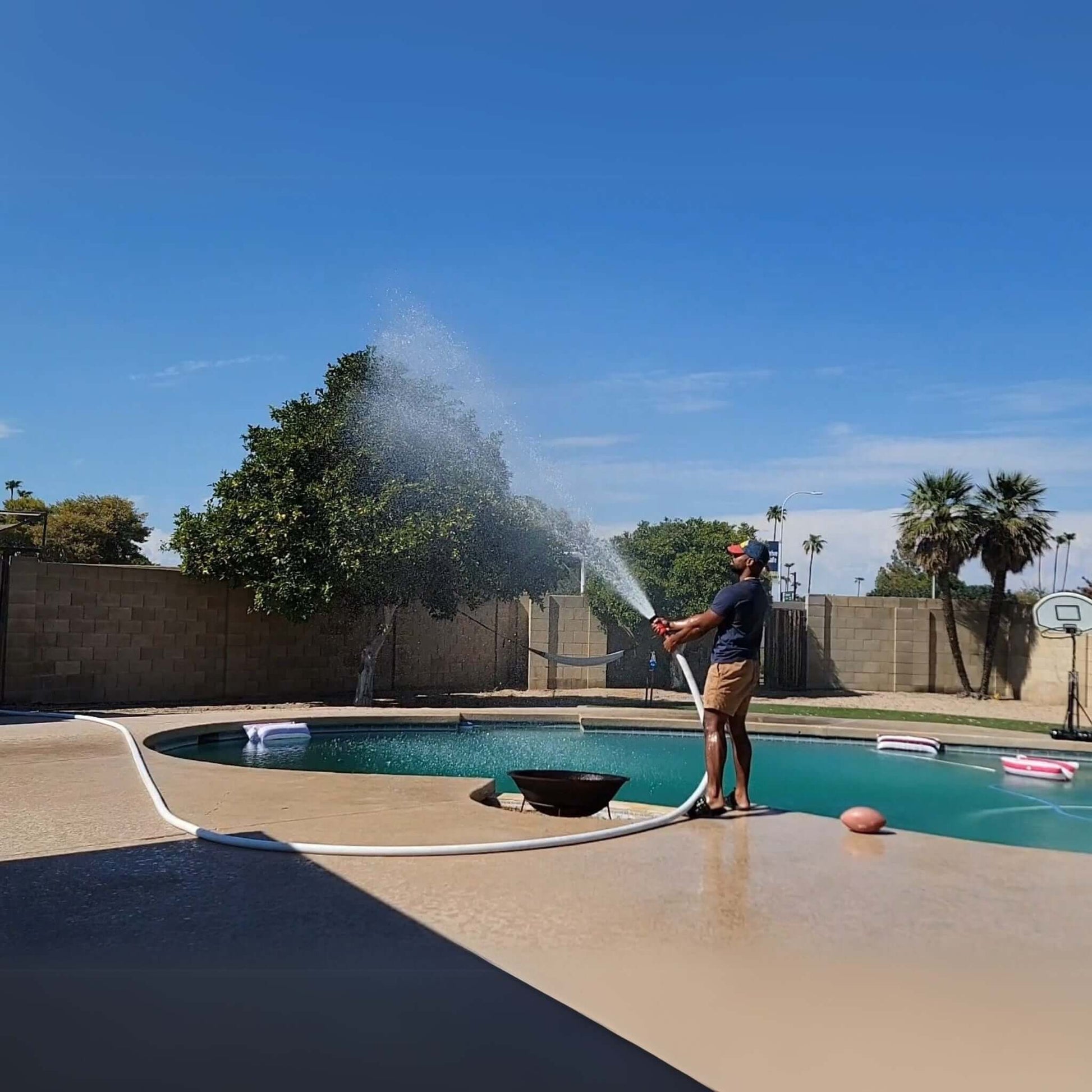 Man using FireFighter1 fire hose for pool pump at Wholesale Pool Mart WPM to protect property from wildfires.